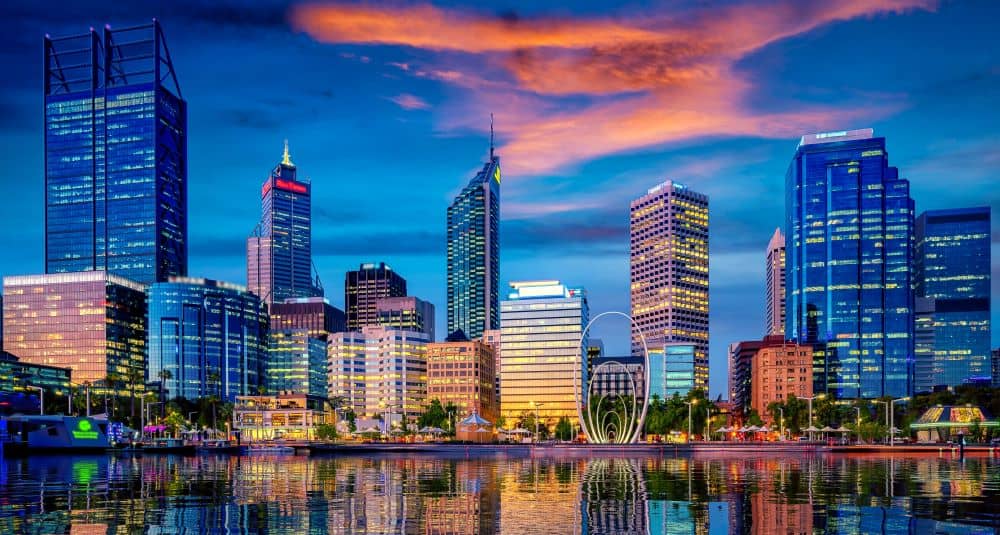 Buildings and skyscrapers across the river during sunset.