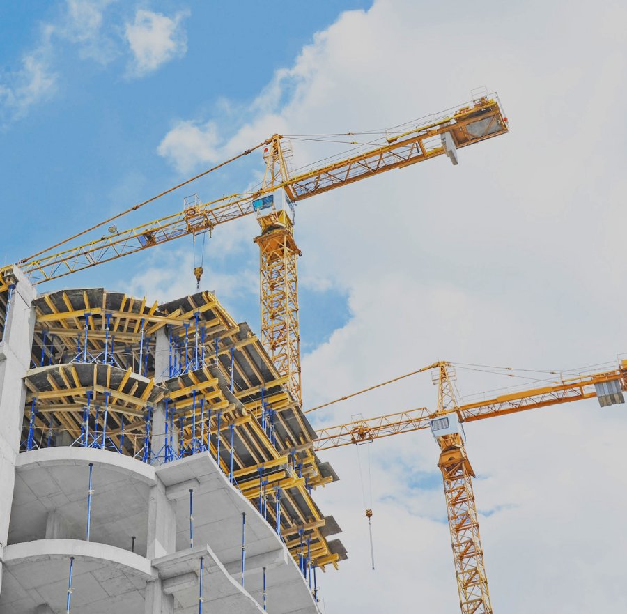 Crane and building construction site against blue sky