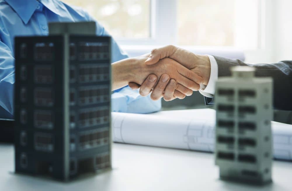 A private lender shaking hands with a client after approving a bridging loan.