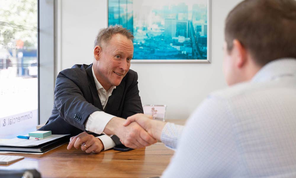 Gavin Harrigan and a client shaking hands